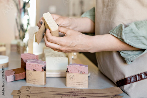 Fotografija A soap maker girl holds a piece of freshly brewed handmade soap in her hands
