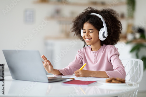 Positive kid having online party with friends while staying home