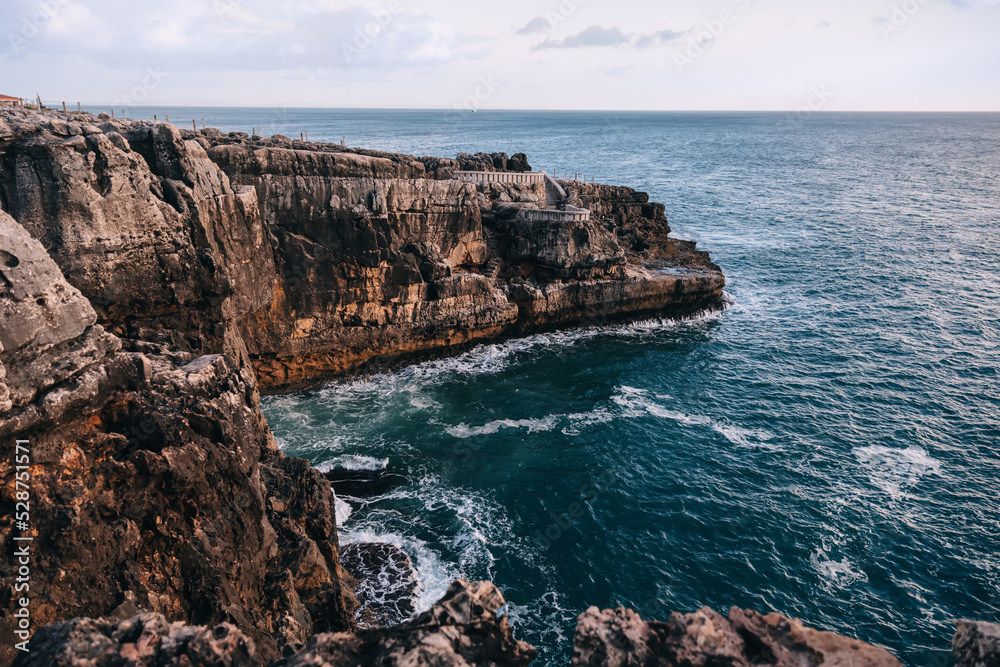 Rocks and cliffs on the shore of the ocean. the sky merges with