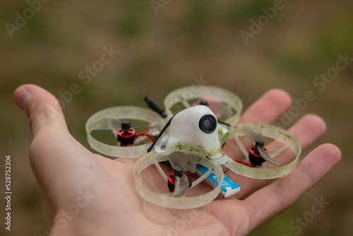 Mini FPV drone in the palm of hand. Small quadcopter with protection for indoor flights,