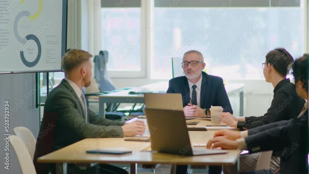 Team of business people in formalwear having discussion senior CEO during corporate meeting in office Team of business people in formalwear having discussion senior CEO during corporate meeting in office