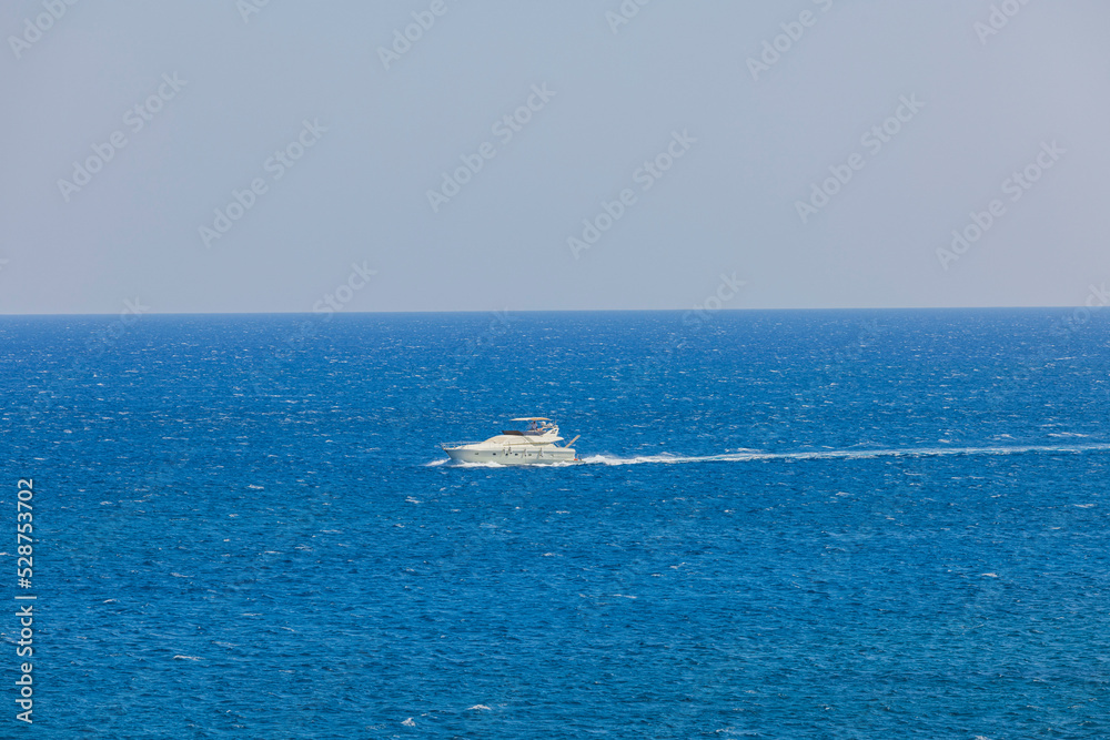 Beautiful view of sailing yacht in sea. Blue sea water surface and blue sky background. Greece. Beautiful view of sailing yacht in sea. Blue sea water surface and blue sky background. Greece.