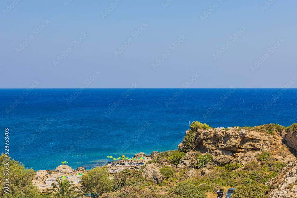 Beautiful view of rocky coastline. Blue sea water and sky merge at horizon. Greece. Beautiful view of rocky coastline. Blue sea water and sky merge at horizon. Greece.