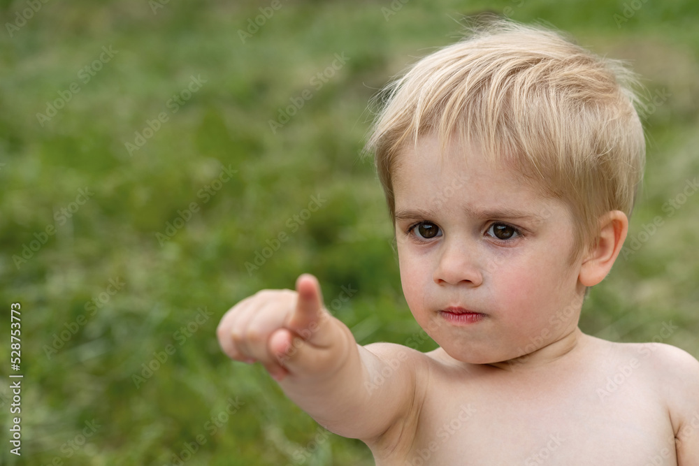 Nice offended kid with insulted expression face. The boy points his finger forward (concept children's emotions) Nice offended kid with insulted expression face. The boy points his finger forward (concept children's emotions)
