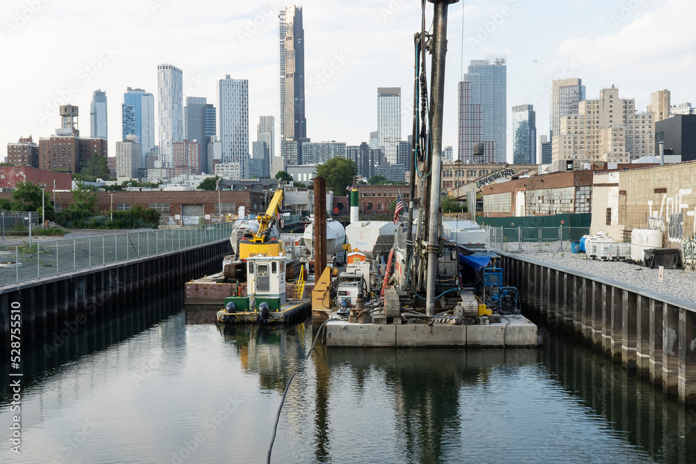Naklejka premium The Gowanus Canal in the Gowanus Neighborhood of Brooklyn, Barges and Buoy in Canal, Brooklyn, NY, USA.