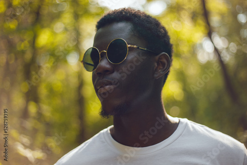 Portrait of an african american man against the background of a green forest.