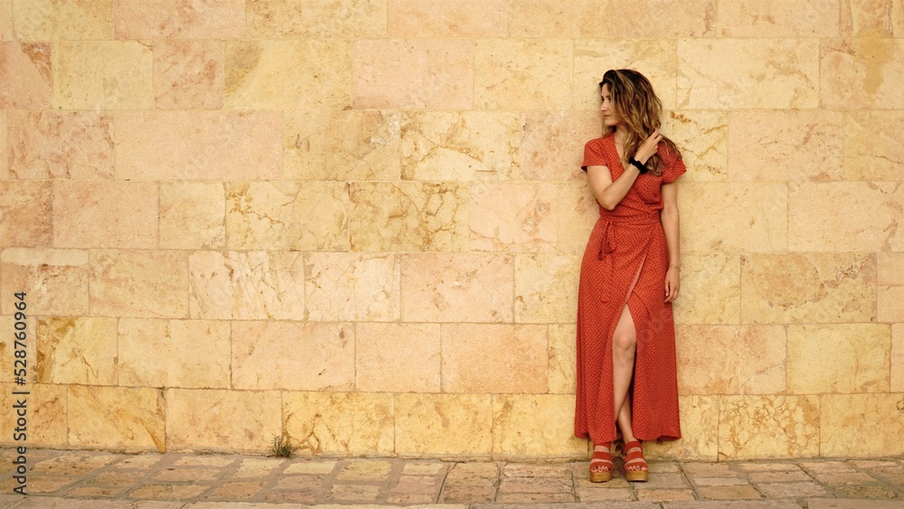 woman standing in red dress on the sidewalk