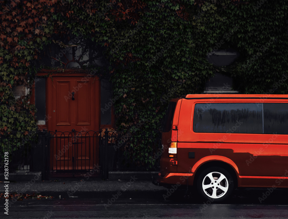 Obraz premium Red minivan parks in front of a house with a red door, ilustration