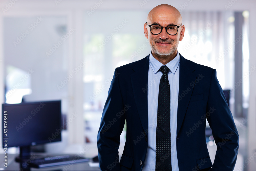 Middle aged businessman standing at the office Middle aged businessman standing at the office
