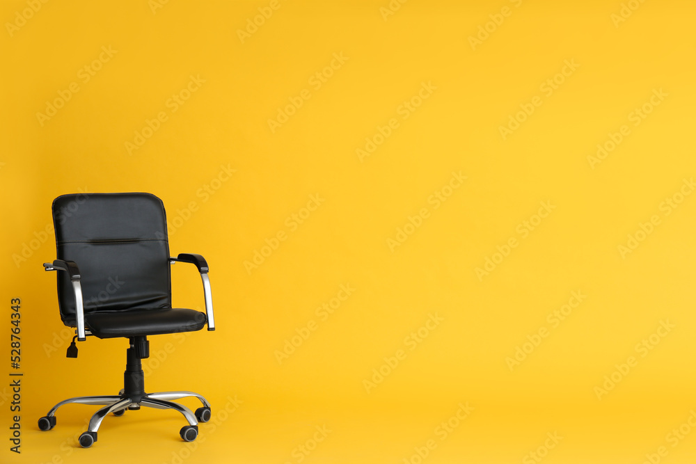 Modern office chair on yellow background. Space for text Modern office chair on yellow background. Space for text