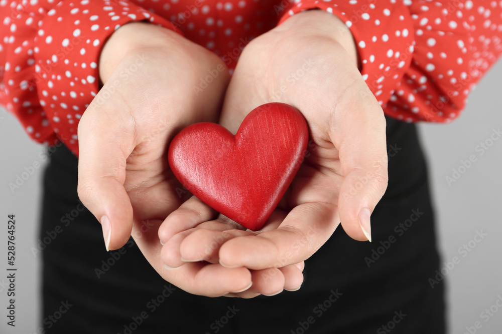 Woman holding red heart on grey background, closeup. Happy Valentine's Day Woman holding red heart on grey background, closeup. Happy Valentine's Day