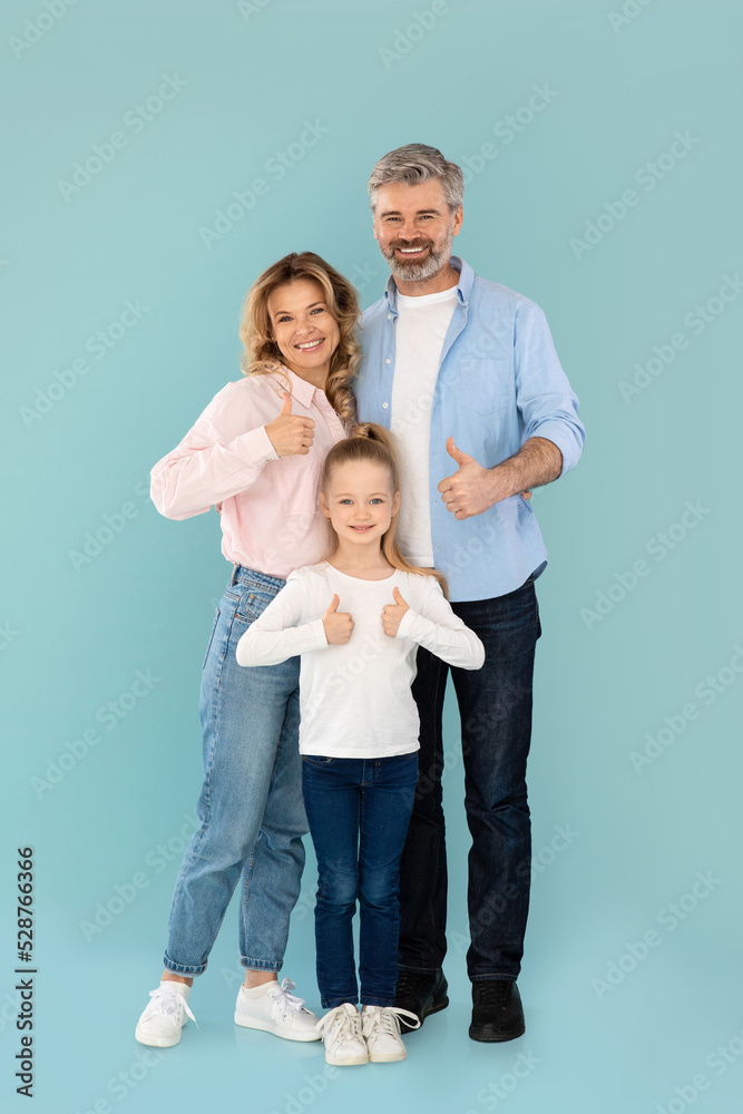 Vertical Shot Of Family Gesturing Thumbs Up On Blue Background Vertical Shot Of Family Gesturing Thumbs Up On Blue Background