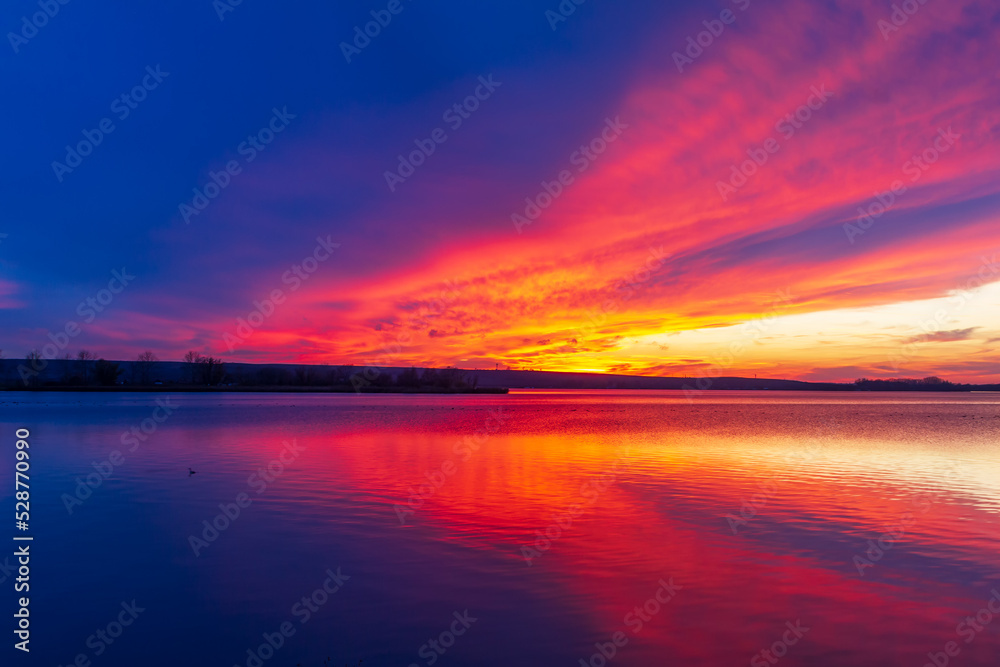 Lake Musov in Palava region in Czech Republic Europe. A dramatic sunset sky is reflected on the surface of the lake.