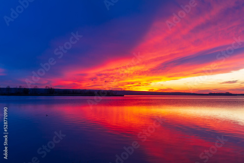 Lake Musov in Palava region in Czech Republic Europe. A dramatic sunset sky is reflected on the surface of the lake. © Roman Bjuty
