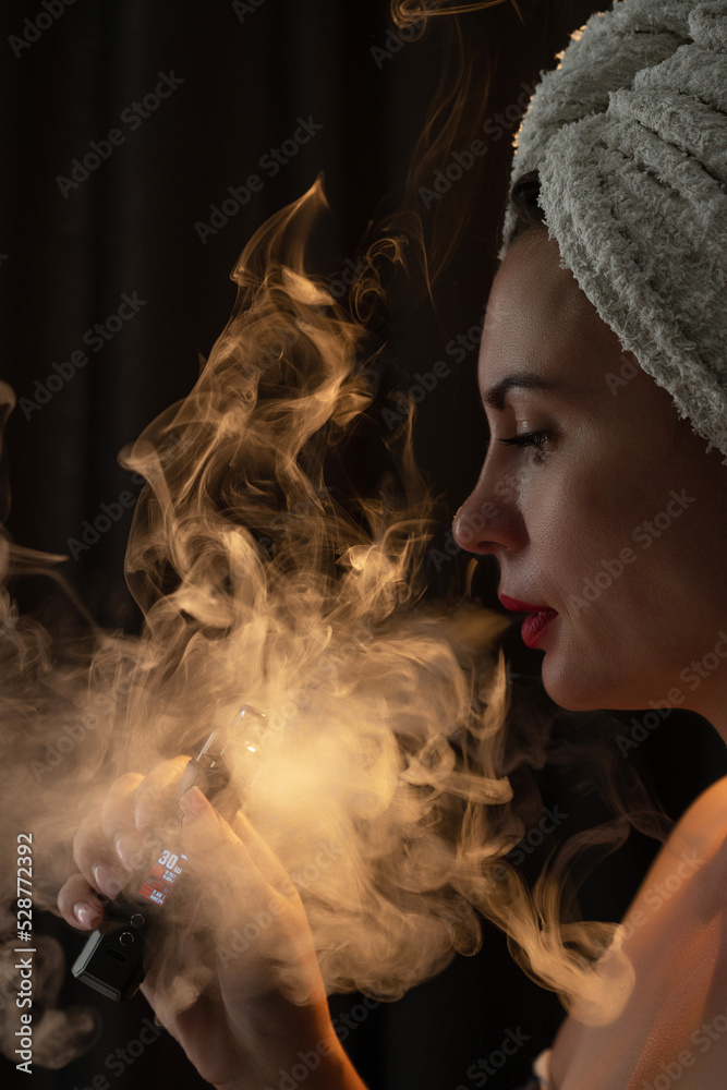 A girl is blowing smoke from a vape, a portrait of a girl with red lips who smokes.