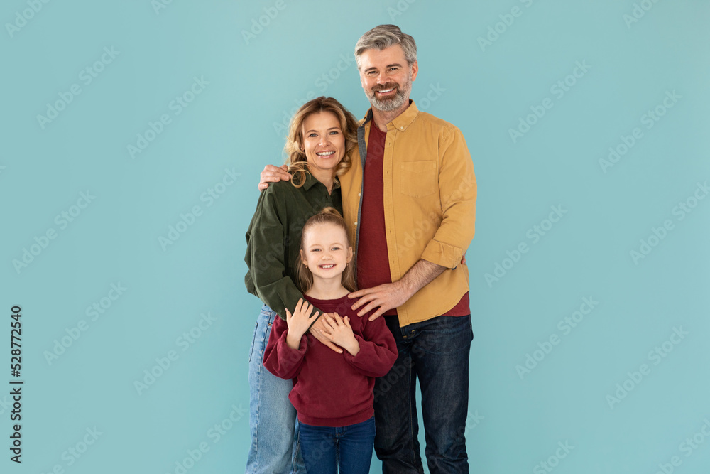 Cheerful Middle Aged Parents And Daughter Hugging Over Blue Background Cheerful Middle Aged Parents And Daughter Hugging Over Blue Background