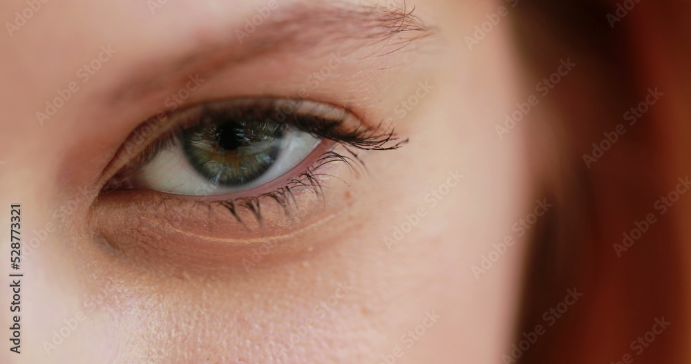 Obraz premium Macro closeup of girl opening eye, redhair woman with green eyes