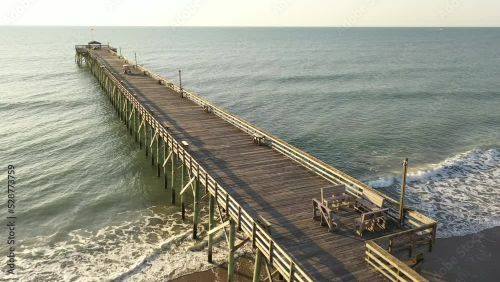 Fishing pier in early morning sun at coastal vacation destination