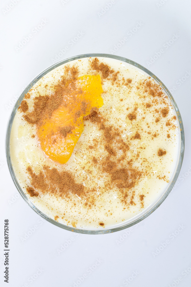 Delicious rice pudding with cinnamon and with a touch of orange, presented in a bowl. Delicious rice pudding with cinnamon and with a touch of orange, presented in a bowl.