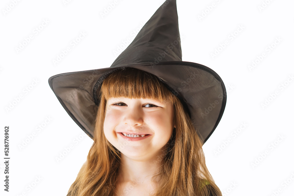 A little blonde Caucasian girl in a black witch costume.Portrait of a happy little baby girl in a black witch hat on a white background. Happy Halloween. October 31, the eve of All Saints' Day A little blonde Caucasian girl in a black witch costume.Portrait of a happy little baby girl in a black witch hat on a white background. Happy Halloween. October 31, the eve of All Saints' Day