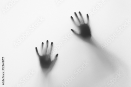 Foto Defocused hand silhouette behind frosted glass in black and white mode, hallowee