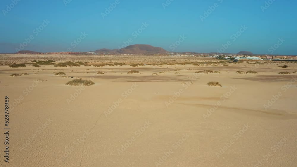Fuerteventura, Canary Islands, Spain. Aerial view of highway along endless sand dunes. Desert landscape. Volcanic mountains. Natural Park. Go everywhere. Asphalt road with cars. Cityscape Corralejo.