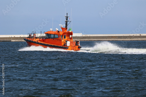 Pomarańczowy statek ratunkowy płynie z pomocą rozbitkom.  photo