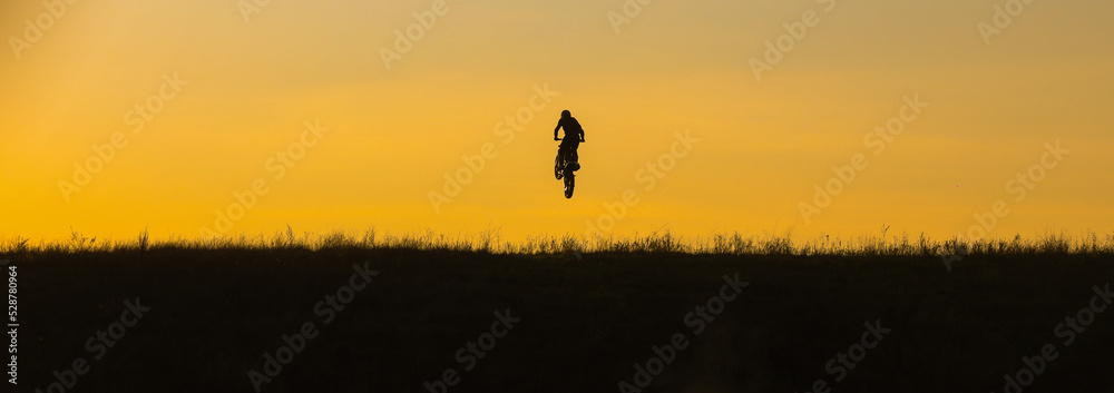 motocross at sunset silhouette of a motorcycle on the field