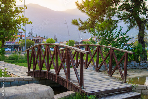 Wooden decorative bridge in a Turkish public park with haze at sunset. Background