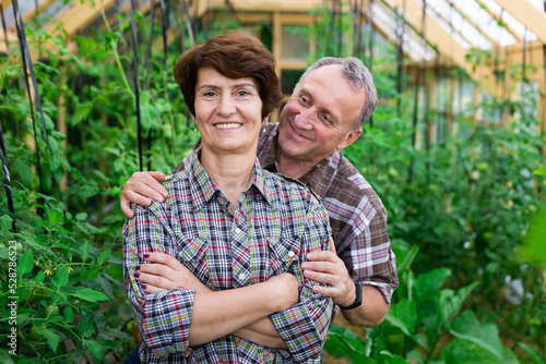 Portrait of happy elderly couple in the greenhouse © caftor