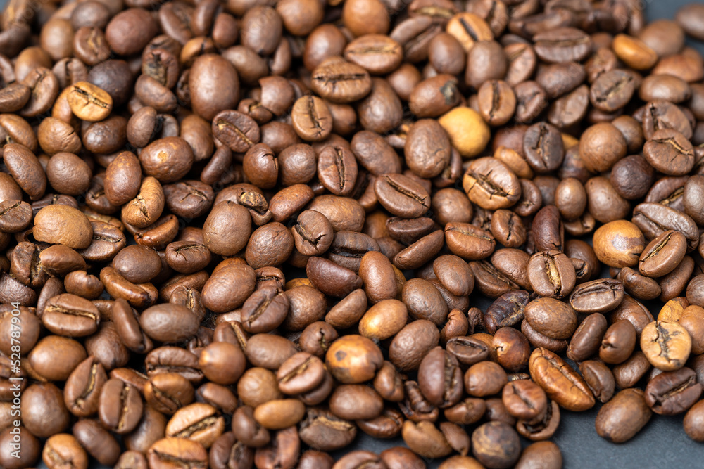 Top view of roasted coffee beans for background and texture. A pile of roasted and ground coffee beans can be used as a background and texture.