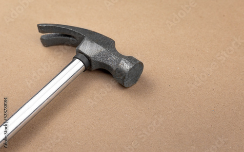 Iron hammer isolated on a table with a textured brown paper background