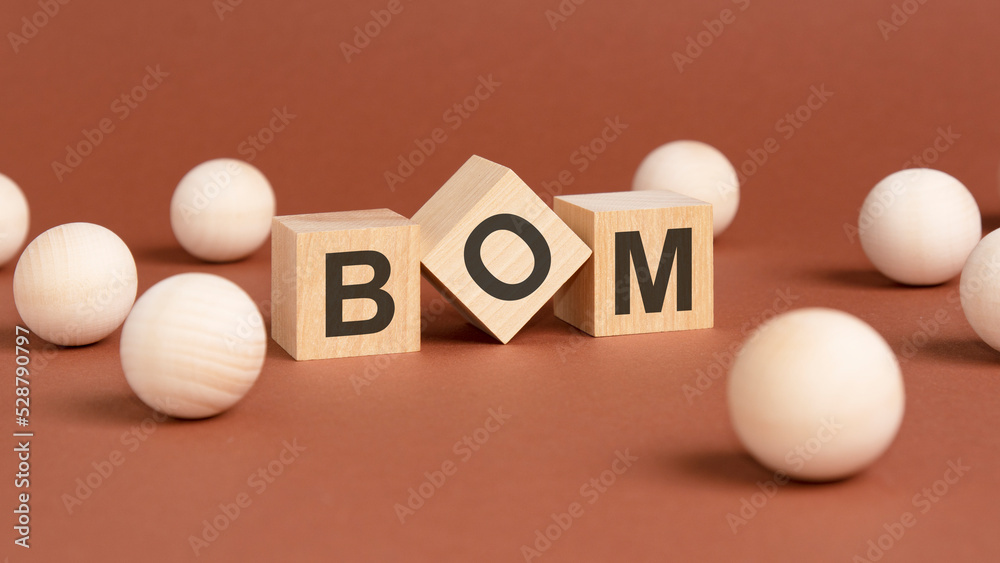 wooden cubes with word BOM on brown background. front view wooden cubes with word BOM on brown background. front view
