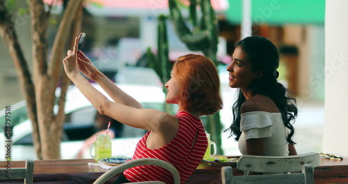 Two multi-ethnic diverse girl taking selfie outside