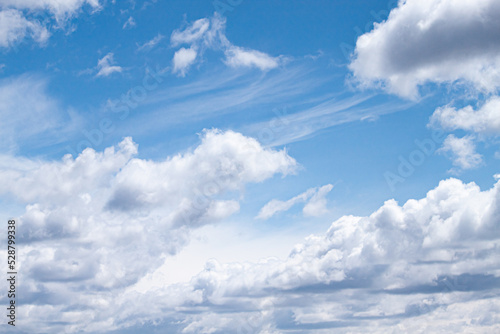 Cumulus clouds blown by the wind across the sky background.