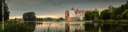 Mir Castle, Belarus. Scenic panoramic view of the complex across the lake with reflections on the water in the evening twilight. UNESCO world heritage photo