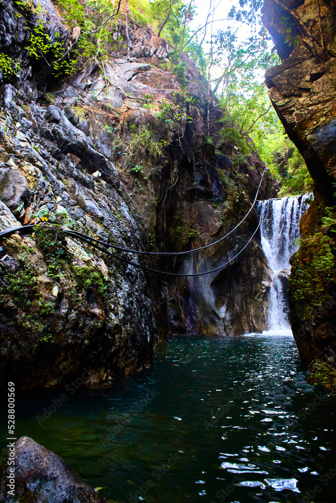 Φωτογραφία waterfall with walls of stone and river turquoise color and green jungle in palo