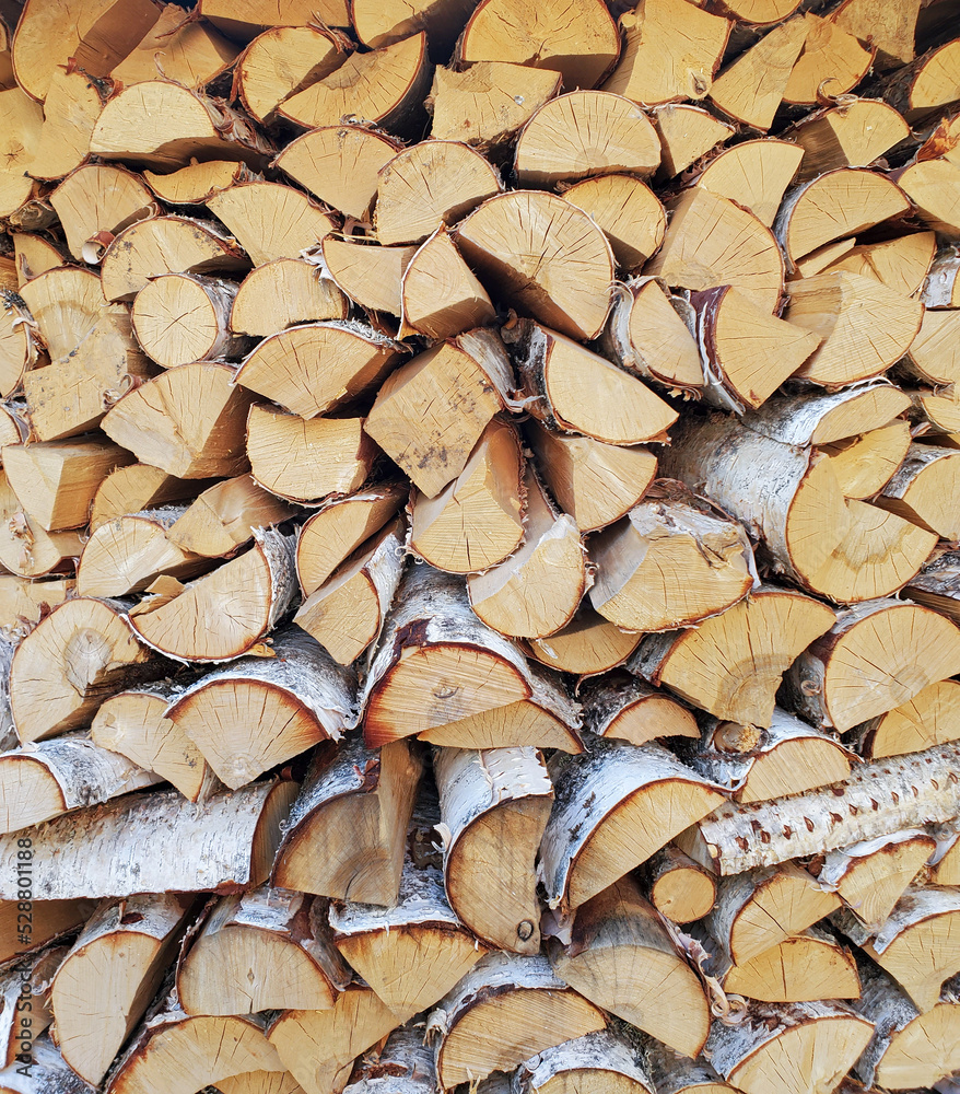 A stack of firewood, log ends, chopped birch and pine firewood. Vertical texture A stack of firewood, log ends, chopped birch and pine firewood. Vertical texture