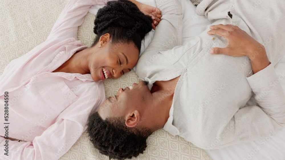 Happy black couple bonding in bed, talking, relax and laughing together in a bedroom. Above young man and woman sharing a loving, romantic moment and enjoying a conversation and relationship indoors Happy black couple bonding in bed, talking, relax and laughing together in a bedroom. Above young man and woman sharing a loving, romantic moment and enjoying a conversation and relationship indoors