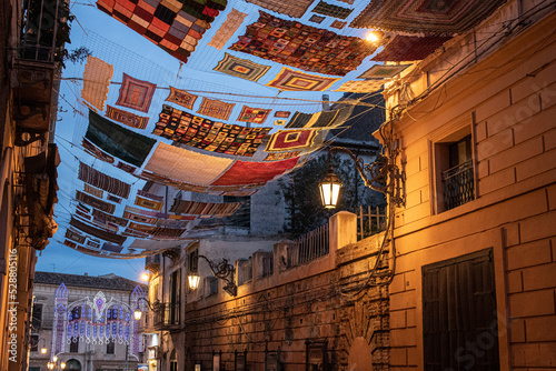 Photos Large colored crochet cloth suspended between the buildings of the city of Rossano in Calabria