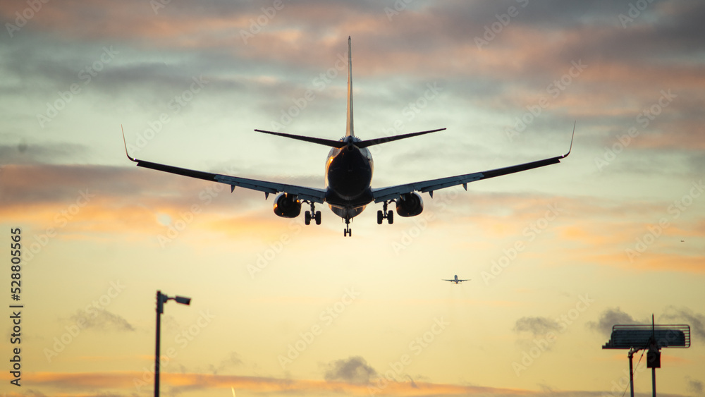 The silhouette of a passenger plane coming in for landing against the backdrop of the sunset sky. The silhouette of a passenger plane coming in for landing against the backdrop of the sunset sky.