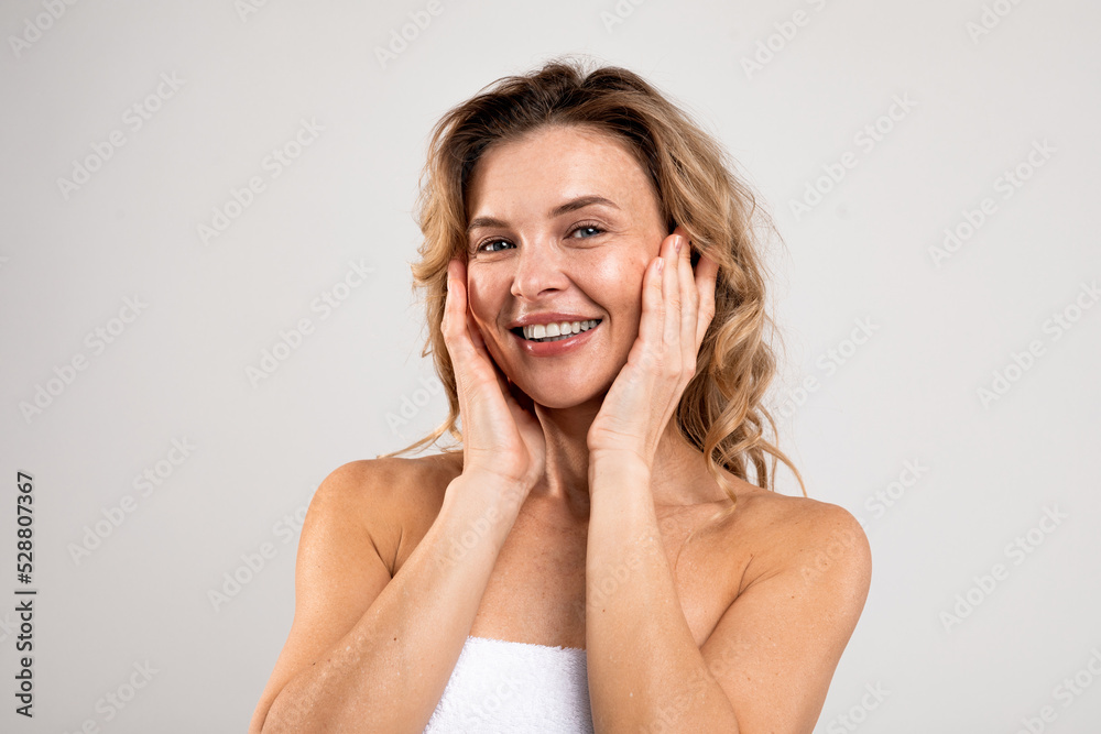 Antiage Skincare. Attractive Middle Aged Female Touching Face And Smiling At Camera - obrazy, fototapety, plakaty 
