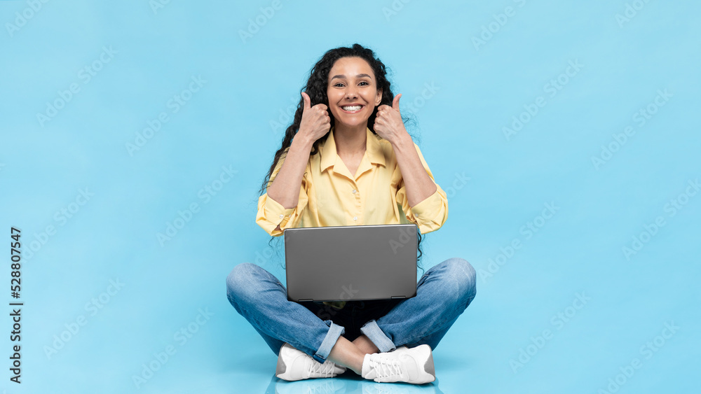 Obraz premium Happy Arabic Woman Using Laptop Gesturing Thumbs Up, Blue Background