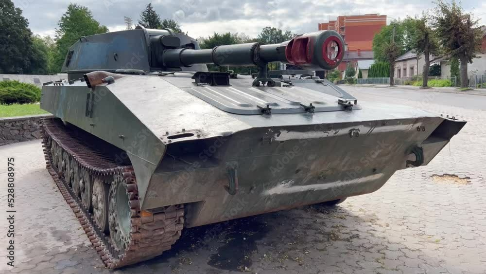 Tank in the war. A tracked self-propelled military howitzer stands on a city street. Russian artillery howitzer. A destroyed Russian howitzer during the war in Ukraine.