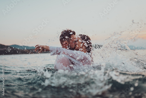 Romantic couple kissing in the sea at sunset. High quality photo photo