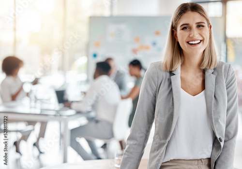 Portrait of a happy business manager and boss of a creative team of startup advertising designers. Proud, smiling businesswoman or leader feeling confident and happiness while working in the office photo
