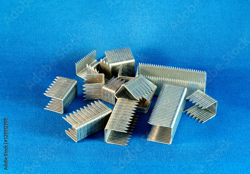 Staples for a staple gun isolated on a blue background.