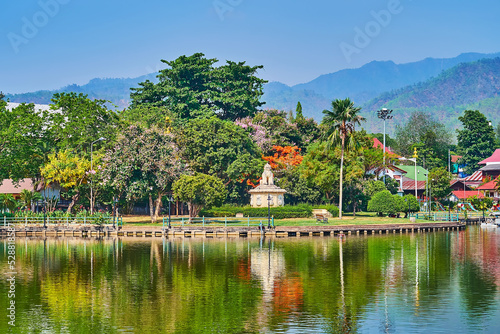 The green park and Singha statue on Nong Kham Lake, architecture, Mae Hong Son, Thailand photo
