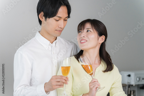 キッチンで乾杯する日本人夫婦