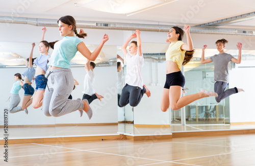 Group of cheerful tweens jumping during modern dances class